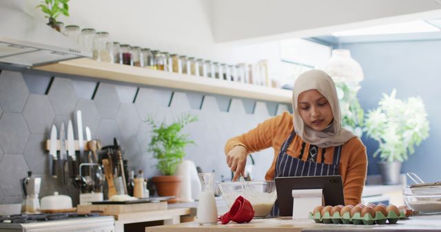 Woman in Hijab Baking at Home, Following Recipe on Tablet - Download Free Stock Images Pikwizard.com