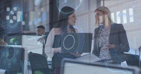 Businesswomen Analyzing Digital Data with High-Tech Overlay in Modern Office