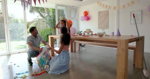 Family cleaning up party decorations after celebration