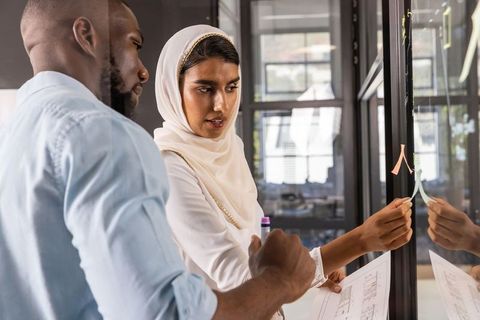 Diverse Team Collaborating on Architecture Project with Sticky Notes