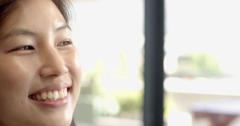 Woman Smiling in Cafe with Sunlit Background