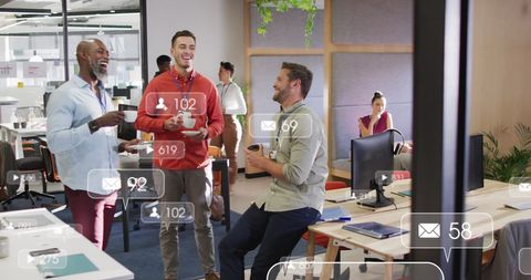 Coworkers discussing with email and social media notifications in office