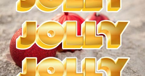 Festive Christmas Text with Red Baubles on Sand