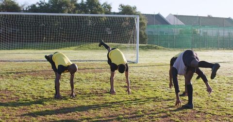 Soccer Teammates Warming Up with Leg Raises on Field