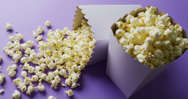 Close-Up of Tipped White Popcorn Tubs on Purple Background - Download Free Stock Images Pikwizard.com