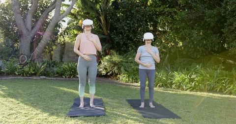 Mother and Daughter Enjoying Virtual Reality Yoga Outdoors