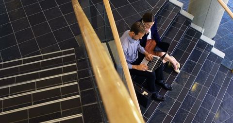 Young Professionals Collaborating on Laptop in Office Stairwell - Download Free Stock Images Pikwizard.com