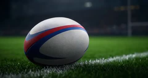 Dynamic Rugby Ball Close-up on Sideline Under Stadium Floodlights