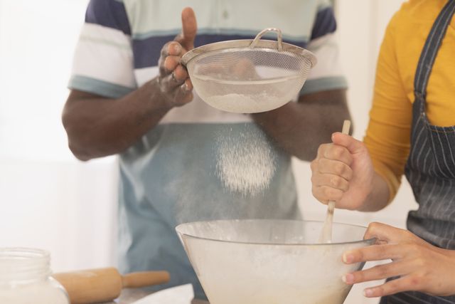 Diverse couple baking together in home kitchen - Download Free Stock Images Pikwizard.com