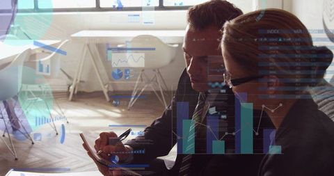 Executives analyzing tablet data and collaborating with analytics overlays in bright office