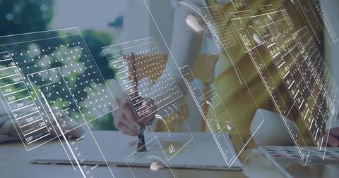 Writing woman in mustard blazer holding pen over notebook with AR data overlays
