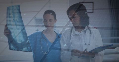 Healthcare team analyzing x-ray with digital interface in clinic