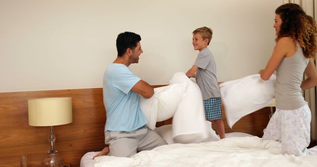 Family Enjoying Pillow Fight in Modern Bedroom - Download Free Stock Images Pikwizard.com