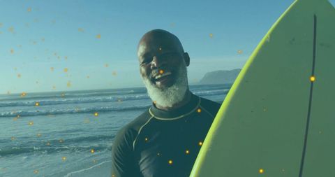 Joyful man with surfboard on sunny ocean shore