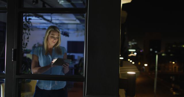 Image of caucasian woman with tablet working late in office - Download Free Stock Photos Pikwizard.com