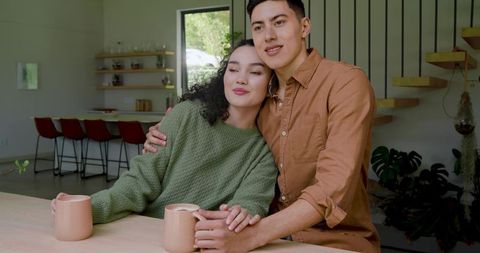 Couple enjoying intimate moment in modern kitchen with coffee