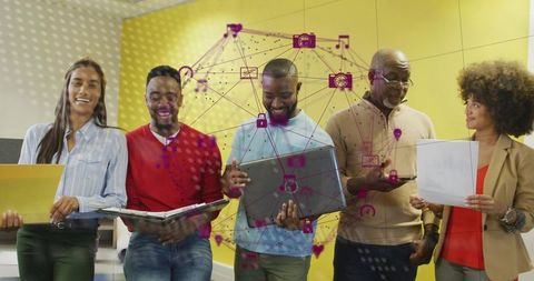 Multigenerational team collaborating with laptops and phones, digital network overlay icons