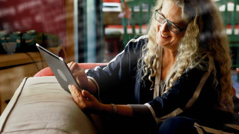 Senior Woman Engaged in Virtual Communication Using Tablet at Home