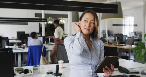 Professional woman tablet workspace open-plan office environment