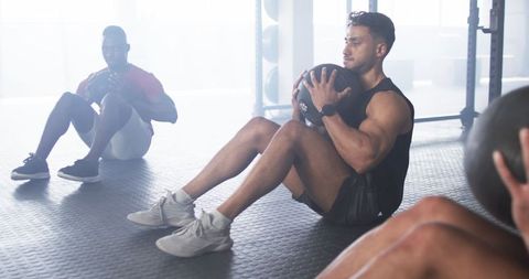 Men Exercising with Medicine Balls in Gym for Core Strength