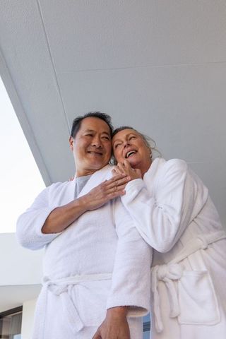 Senior couple relaxing on cruise ship balcony in bathrobes
