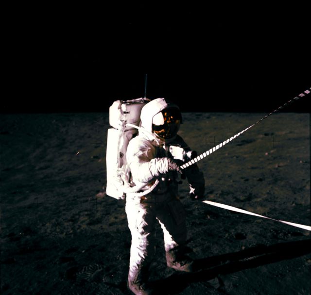 Astronaut in full space suit using a lunar equipment conveyer during a mission on the moon's surface. Ideal for content related to space exploration, scientific achievements, historical events, and space technology. Perfect for educational materials, science fiction graphics, and articles on NASA missions.