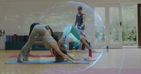 Group practicing yoga using augmented reality overlay in bright fitness studio