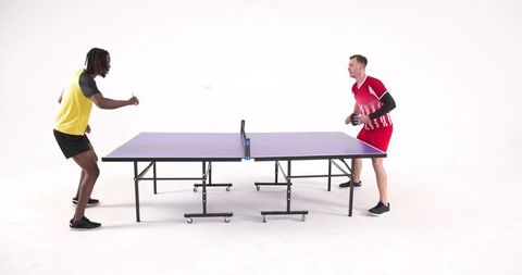 Athletes competing in recreational table tennis match in studio