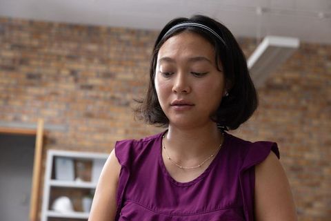 Focused Asian Designer Sketching in Trendy Brick Studio