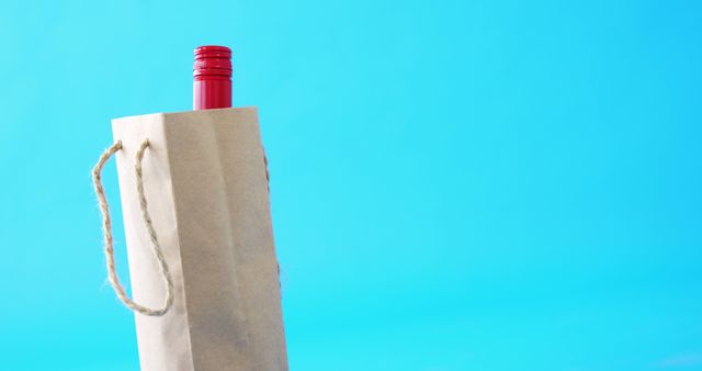 Wine Bottle in Paper Bag Against Blue Background - Download Free Stock Images Pikwizard.com