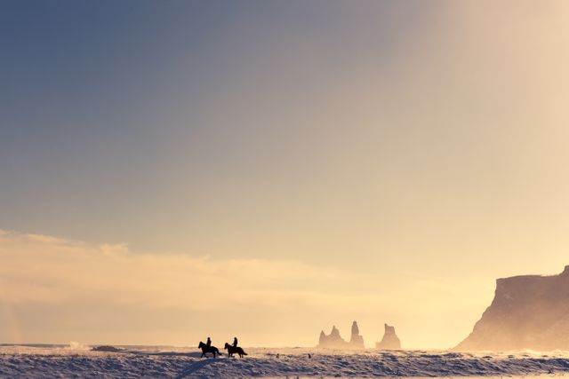 Horseback Riders at Dawn on Snowy Landscape with Rock Formations in Distance - Download Free Stock Images Pikwizard.com