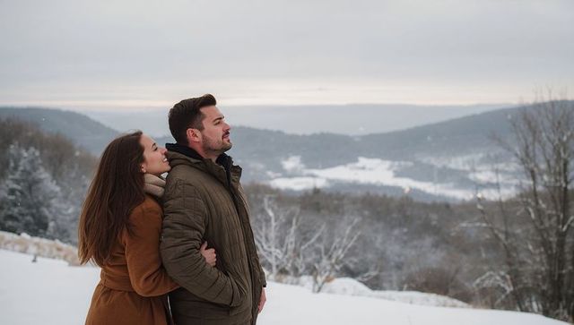 Couple Embracing and Gazing Over Snowy Valley at Dusk
