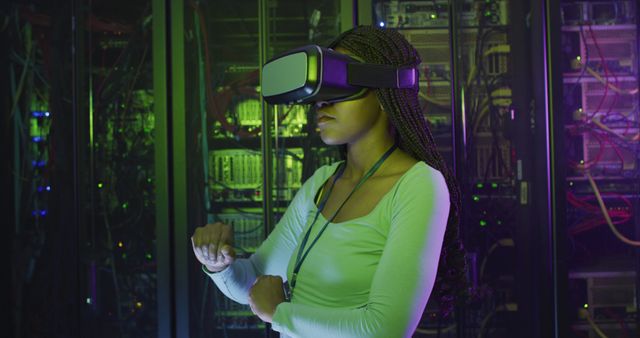 Female technician in green light environment wearing a virtual reality headset and interacting with virtual objects in a data center filled with servers and network equipment. Ideal for depicting concepts related to technology use, futuristic work environments, and cybersecurity advancements.
