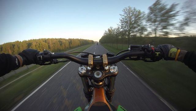 Pov motorcycle ride racing down open country road at golden hour