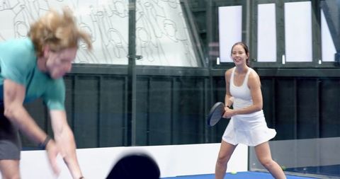 Energetic Women Paddling on a Indoor Padel Court