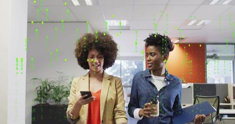 Two colleagues walking with phone and coffee under green binary code overlay in office