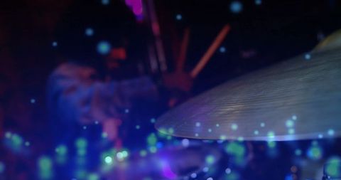 Energetic drummer performing on stage with vibrant lights