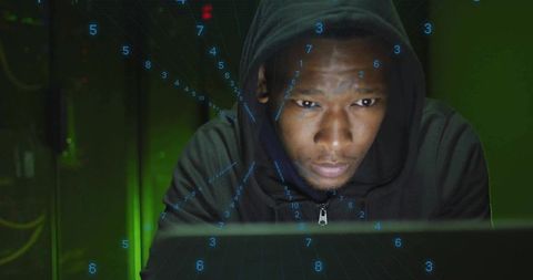Focused Hooded Man Typing Commands in Futuristic Setting