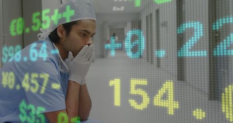 Worried Surgeon with Overlay of Stock Market Data in Hospital Lobby