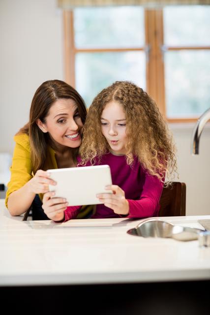 Mother and Daughter Using Tablet in Kitchen at Home - Download Free Stock Photos Pikwizard.com