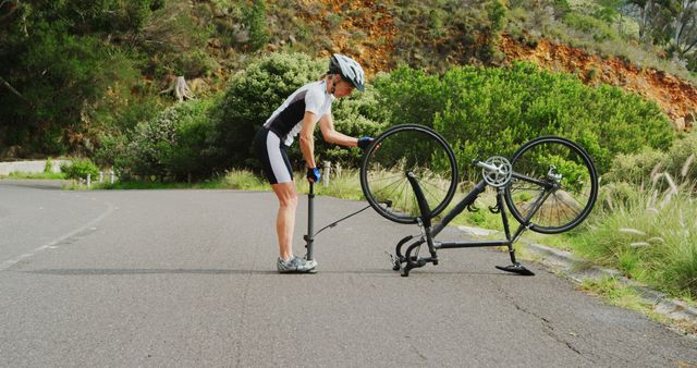 Cyclist Fixing Flat Tire on Rural Road - Download Free Stock Images Pikwizard.com