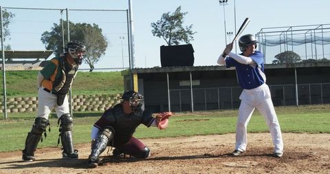 Batter preparing to swing with catcher and umpire in position