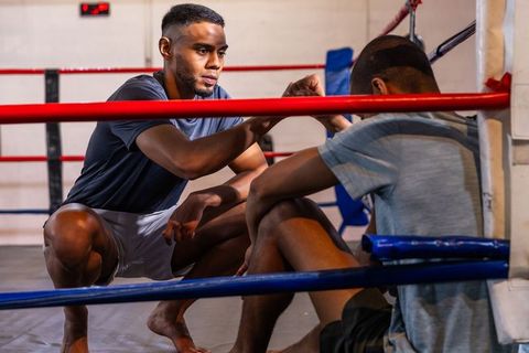 Coach guiding boxer in corner showing focus resilience and teamwork during training