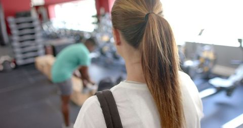 Young caucasian woman observing gym floor before workout