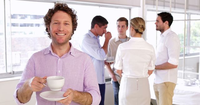 Smiling businessman holding coffee cup in office break room - Download Free Stock Images Pikwizard.com