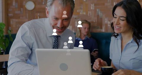 Business team collaborating over laptop in cafe with coffee and social network icons