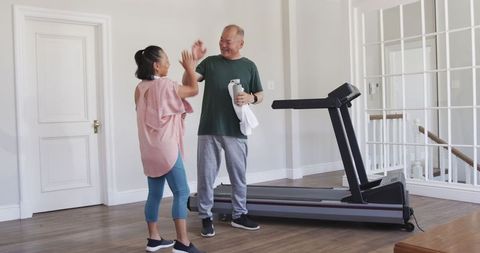 Senior couple embracing fitness at home with treadmill workout