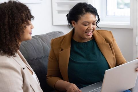 African american coworkers collaborating on laptop during casual office meeting
