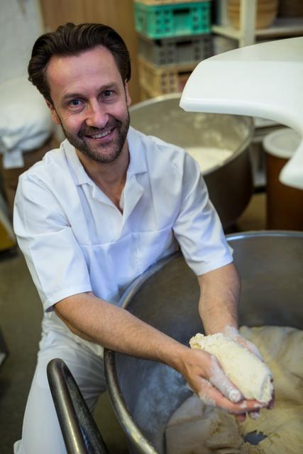 Portrait of smiling baker preparing dough