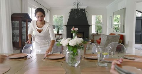 Woman preparing table for elegant wedding celebration in luxury dining room